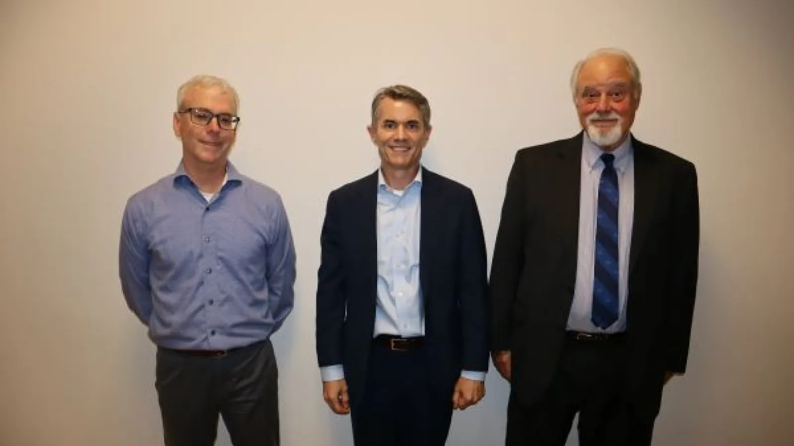 A picture of three board members standing by each other
