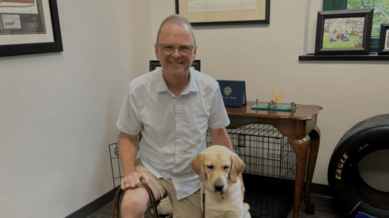 Professor Christopher Gelpi leaning over with his dog Chaz
