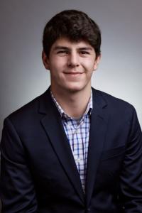 Andre Berrios headshot wearing a suit and checkered shirt